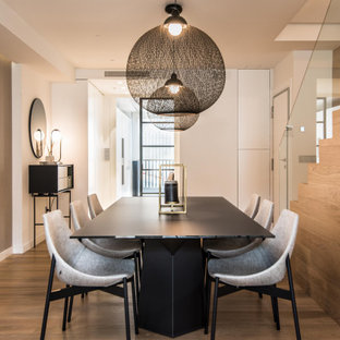 Modelo de comedor contemporáneo, de tamaño medio, con paredes blancas y suelo beige