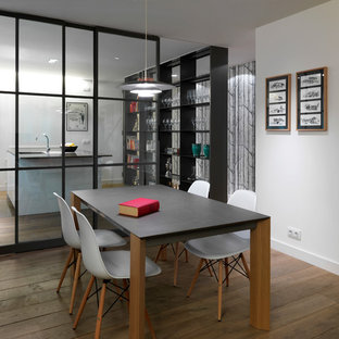 Imagen de comedor contemporáneo, cerrado, con paredes blancas y suelo de madera en tonos medios
