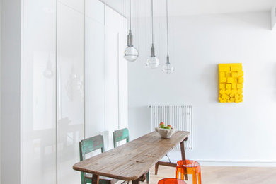 Foto de comedor contemporáneo de tamaño medio cerrado sin chimenea con paredes blancas y suelo de madera en tonos medios
