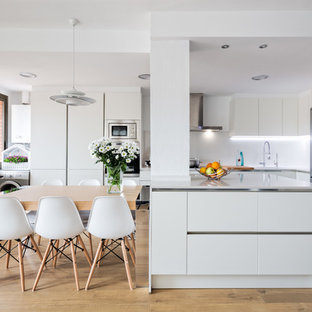 Ejemplo de comedor de cocina nórdico con paredes blancas, suelo de madera clara y suelo beige