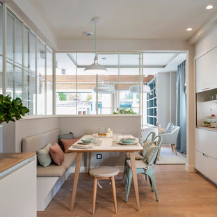 Foto de comedor de cocina nórdico, extra grande, con suelo laminado, suelo marrón y paredes blancas