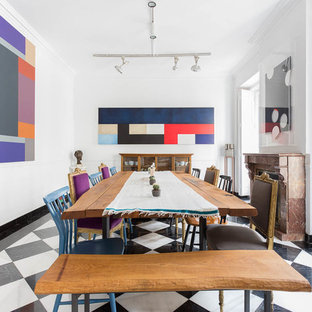Ejemplo de comedor ecléctico, grande, con paredes blancas, suelo de baldosas de porcelana, chimenea tradicional, marco de chimenea de piedra y suelo multicolor