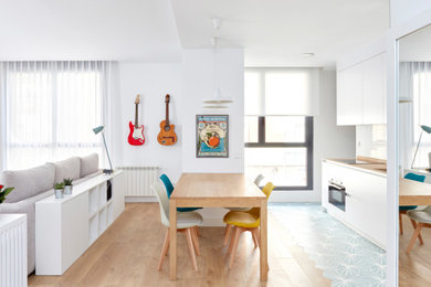 Imagen de comedor minimalista de tamaño medio abierto con paredes blancas y suelo de madera clara
