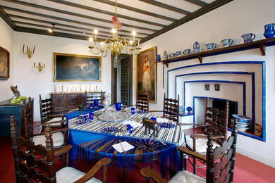 Imagen de comedor mediterráneo grande cerrado con paredes blancas, todas las chimeneas y marco de chimenea de baldosas y/o azulejos