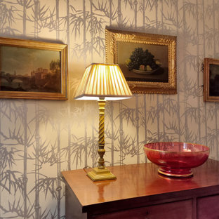 Idée de décoration pour une salle à manger tradition fermée et de taille moyenne avec un mur multicolore, un sol en bois brun, une cheminée standard et un manteau de cheminée en pierre de parement.