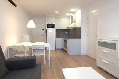Ejemplo de comedor de cocina actual pequeño con paredes blancas, suelo de madera en tonos medios y suelo marrón