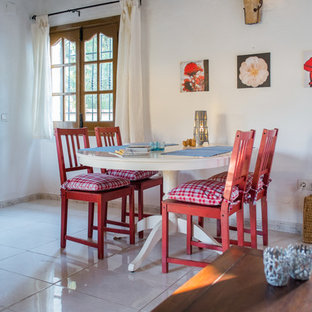 Immagine di una piccola sala da pranzo aperta verso il soggiorno mediterranea con pareti bianche