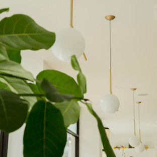 Esempio di una sala da pranzo aperta verso il soggiorno contemporanea di medie dimensioni con pareti bianche, pavimento in gres porcellanato, camino classico, cornice del camino in cemento e pavimento grigio