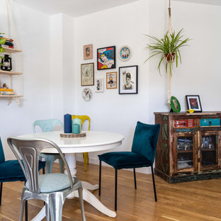 Imagen de comedor bohemio con paredes blancas, suelo de madera en tonos medios y suelo marrón