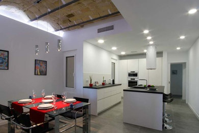 他の地域にあるインダストリアルスタイルのおしゃれなダイニングキッチン (白い壁、暖炉なし) の写真