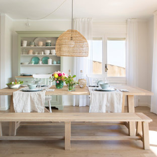 Imagen de comedor marinero con paredes blancas, suelo de madera clara y suelo beige