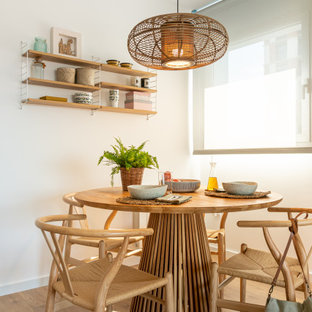 Modelo de comedor actual con paredes blancas, suelo de madera en tonos medios y suelo marrón
