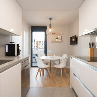 Imagen de comedor de cocina escandinavo, de tamaño medio, con paredes blancas, suelo de baldosas de porcelana y suelo gris