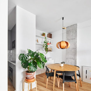 Modelo de comedor actual, abierto, con paredes blancas, suelo de madera clara y suelo beige