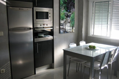 Foto de comedor de cocina minimalista pequeño sin chimenea con paredes grises