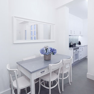 Diseño de comedor mediterráneo con paredes blancas, suelo de cemento y suelo gris