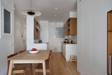 Foto de comedor actual de tamaño medio abierto sin chimenea con paredes blancas y suelo de madera en tonos medios