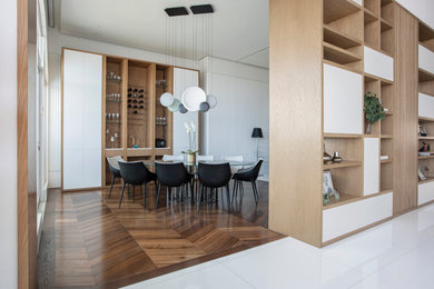 Ejemplo de comedor minimalista grande abierto con paredes blancas, suelo de madera en tonos medios y suelo marrón