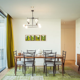 Imagen de comedor retro con paredes blancas, suelo de madera en tonos medios y suelo marrón