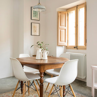 Diseño de comedor mediterráneo con paredes blancas, suelo de cemento y suelo gris