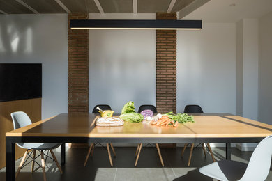 Idée de décoration pour une salle à manger urbaine avec un mur blanc et un sol gris.