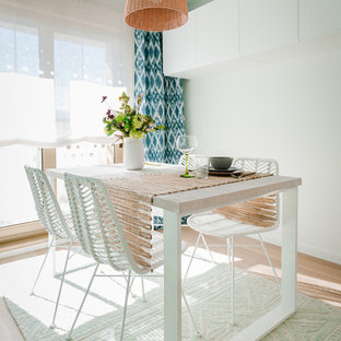 Imagen de comedor costero, sin chimenea, con paredes blancas y suelo de madera clara