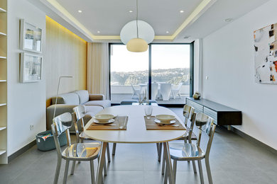 Foto de comedor contemporáneo de tamaño medio abierto sin chimenea con paredes blancas, suelo de baldosas de cerámica y suelo gris
