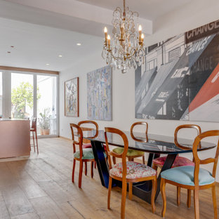 Imagen de comedor de cocina bohemio con paredes blancas, suelo de madera en tonos medios y suelo marrón