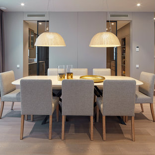 Diseño de comedor contemporáneo, sin chimenea, con paredes grises, suelo de madera clara y suelo beige