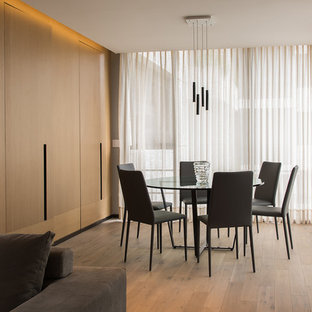 Modelo de comedor contemporáneo con suelo de madera en tonos medios y suelo marrón