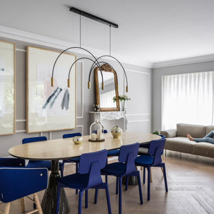 Diseño de comedor panelado, actual, grande, abierto y panelado, con paredes grises, suelo de madera en tonos medios y panelado
