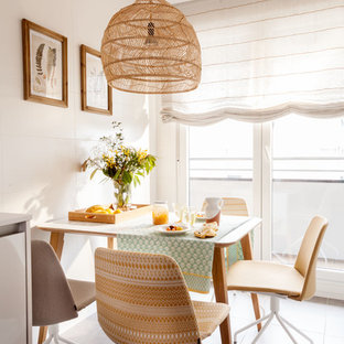 Imagen de comedor de cocina costero con paredes blancas y suelo gris