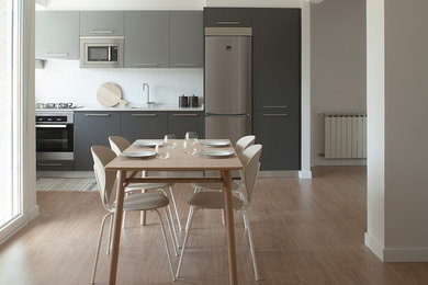 Imagen de comedor nórdico de tamaño medio abierto sin chimenea con paredes blancas y suelo de madera en tonos medios