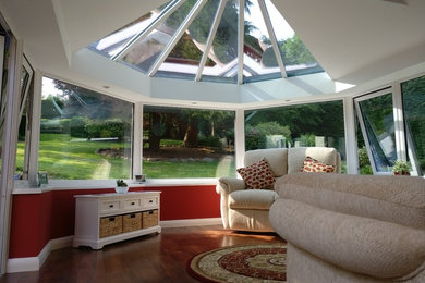 Idee per una veranda minimal di medie dimensioni con parquet scuro, soffitto in vetro e pavimento marrone