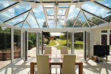Photo of a traditional conservatory in Essex with light hardwood flooring, a glass ceiling and beige floors.