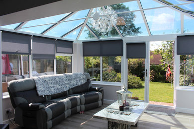 Idee per una veranda minimalista di medie dimensioni con pavimento in legno massello medio, soffitto in vetro e pavimento grigio