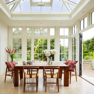 This is an example of a medium sized traditional conservatory in London with marble flooring, beige floors and a glass ceiling.