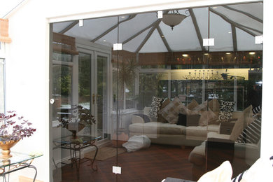 На фото: терраса в современном стиле с паркетным полом среднего тона и стеклянным потолком с