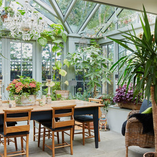 This is an example of a classic conservatory in London with a glass ceiling and grey floors.