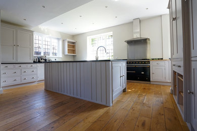 Inspiration for a large contemporary kitchen in Kent with medium hardwood flooring.