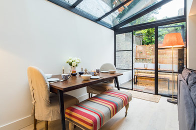 Foto di una veranda design di medie dimensioni con pavimento in legno massello medio, soffitto in vetro e pavimento beige