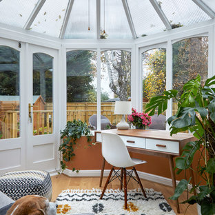 Photo of a traditional conservatory in London with light hardwood flooring, a glass ceiling and beige floors.