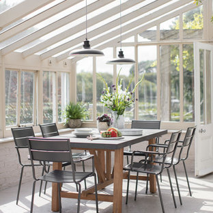 This is an example of a rural conservatory in Oxfordshire with a glass ceiling and beige floors.