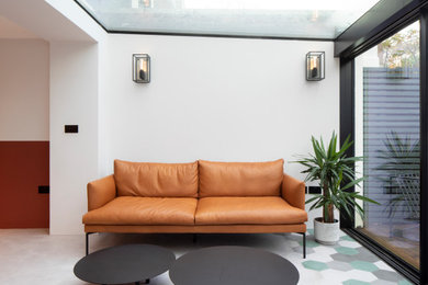 Medium sized modern conservatory in London with concrete flooring, a glass ceiling and grey floors.