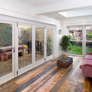 Foto di una veranda eclettica con parquet scuro, lucernario e pavimento marrone