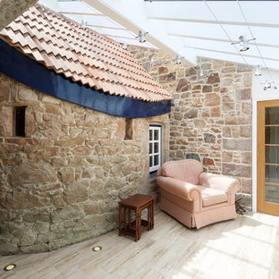 Design ideas for a mediterranean conservatory in Channel Islands with a skylight and beige floors.