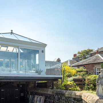 Stilted orangery with glazed balcony and seaside view