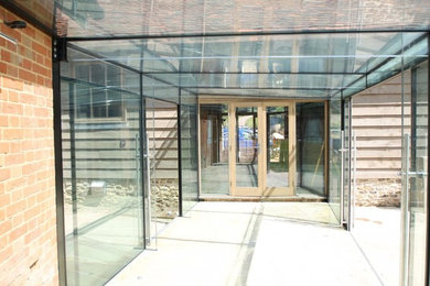Diseño de galería actual de tamaño medio con techo de vidrio y suelo gris