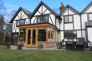 Modelo de galería de estilo de casa de campo de tamaño medio sin chimenea con suelo de madera en tonos medios, techo con claraboya y suelo naranja