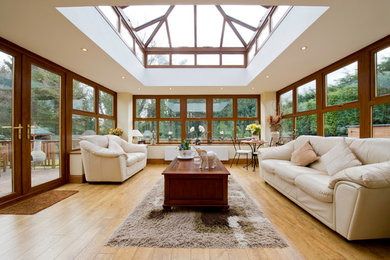 Foto di una veranda tradizionale con pavimento in legno massello medio e soffitto in vetro